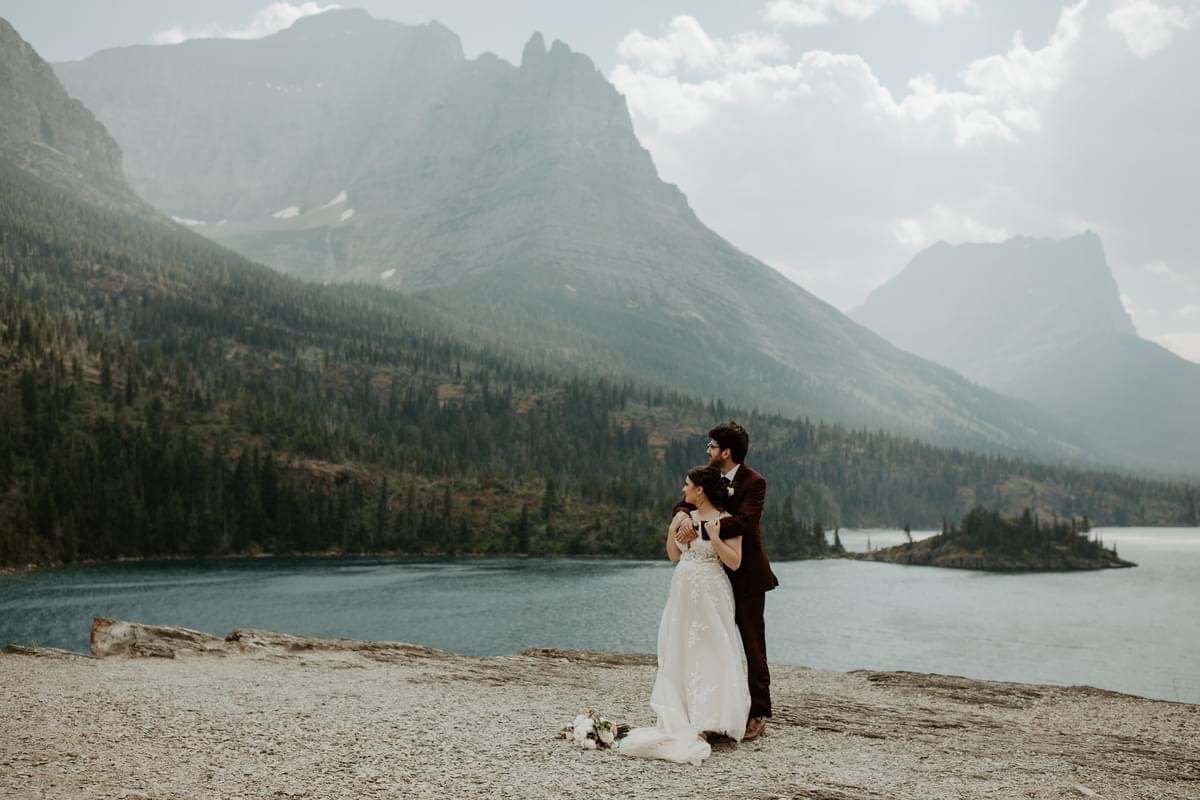 Bride and groom in front of a mountain wall