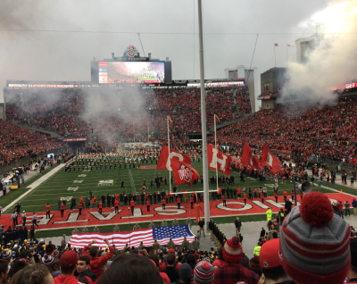picture from inside Ohio Stadium featuring the OHIO flags, an American flag, and pre-game celebrations
